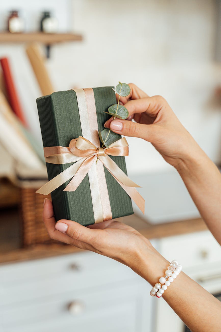 person holding a gift with ribbon